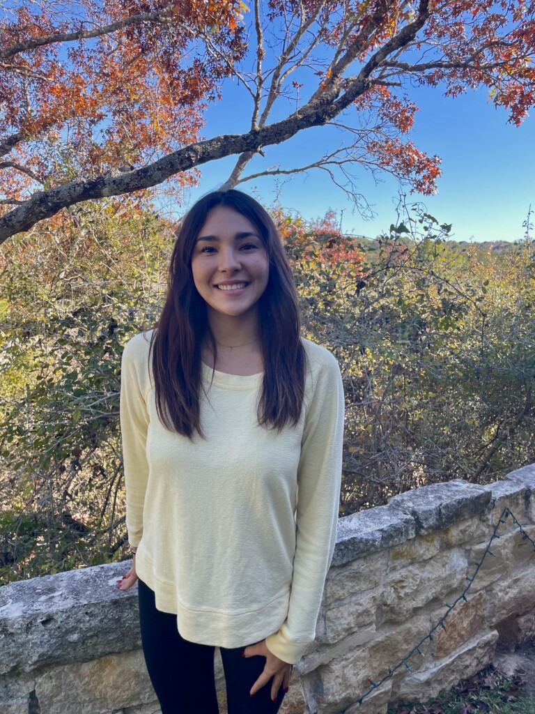 Photograph of Eliana Garza with autumnal trees in the background
